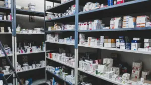 Ein gut gefülltes Arzneimittelregal in einer Apotheke mit zahlreichen Medikamentenschachteln.