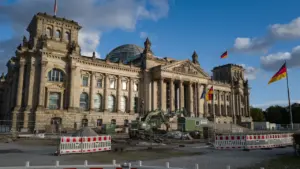 Das Reichstagsgebäude in Berlin bei Tageslicht unter einem blauen, wolkenverhangenen Himmel.