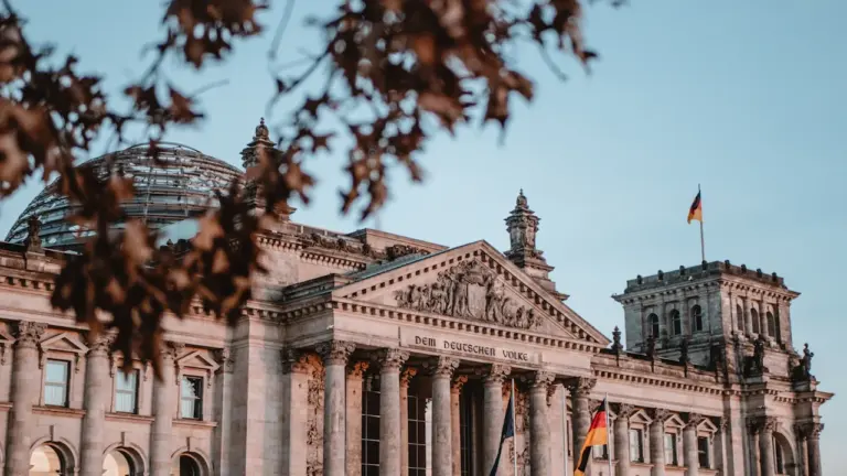Die deutsche Flagge weht vor dem Reichstagsgebäude in Berlin bei Tageslicht.