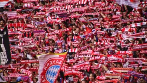 Fans des FC Bayern München in der Allianz Arena mit rot-weißen Schals.