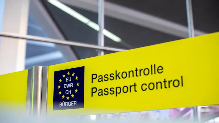 Ein gelbes Schild mit der Aufschrift Passkontrolle an einem internationalen Flughafen.
