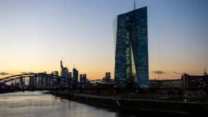 Blick bei Sonnenuntergang auf die Europäische Zentralbank und die Frankfurter Skyline.