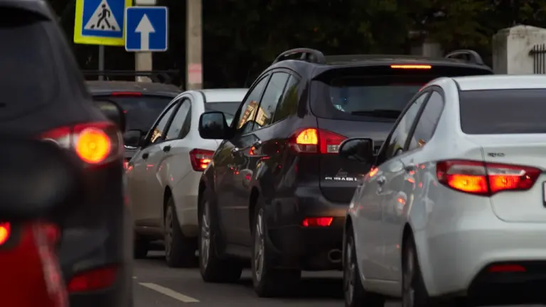 Autos stehen in einer Schlange auf einer belebten Straße im dichten Freitagsverkehr.