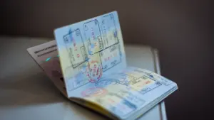 Ein geöffneter Reisepass mit zahlreichen internationalen Einreisestempeln und Visa auf den Seiten.