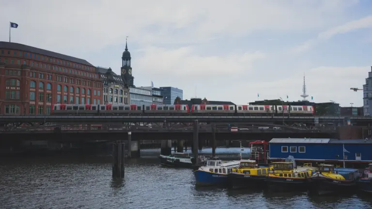 Eine Hamburger S-Bahn überquert eine Brücke über die Elbe bei schönem Tageslicht.