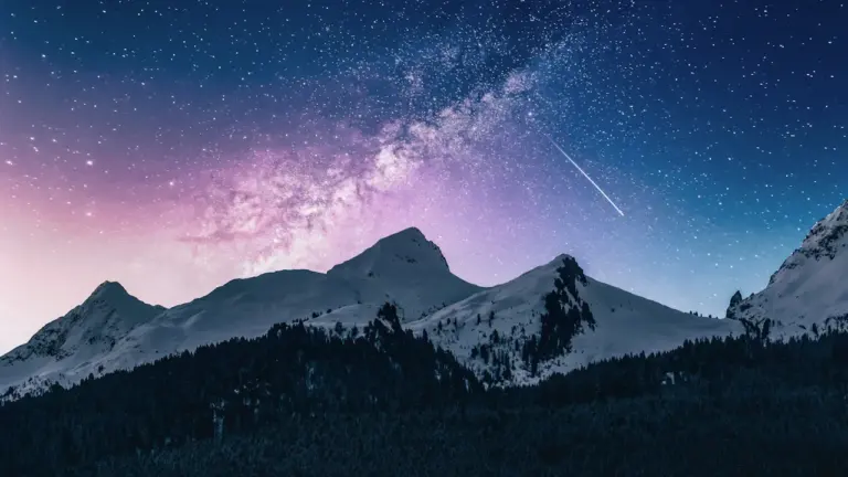 Spektakuläre Sternschnuppen über einer nächtlichen Berglandschaft unter einem klaren Sternenhimmel.