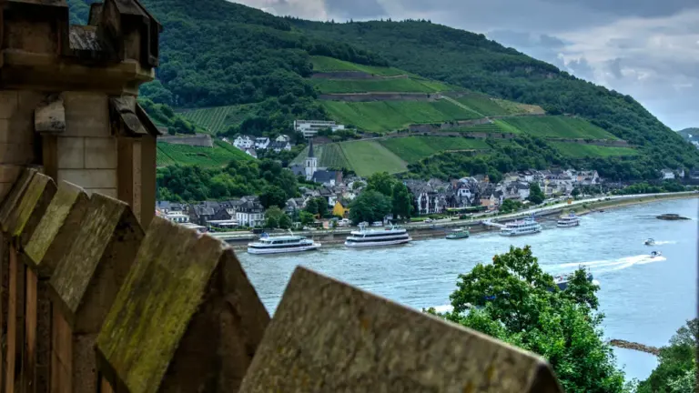 Blick auf den Rhein bei Kaub mit malerischen Weinbergen und vorbeifahrenden Schiffen.