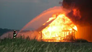 Feuerwehrleute löschen einen Scheunenbrand bei einem Großeinsatz in der Dunkelheit.