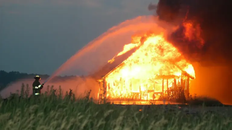 Feuerwehrleute löschen einen Scheunenbrand bei einem Großeinsatz in der Dunkelheit.