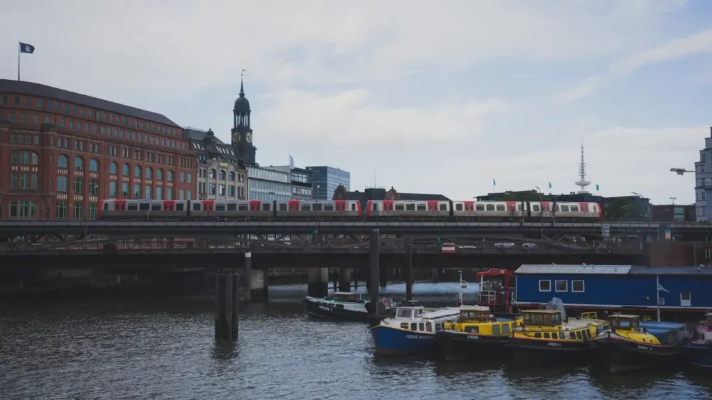 Eine S-Bahn überquert eine Brücke in Hamburg über dem Wasser bei Tageslicht.