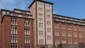 Ein großes, backsteingeprägtes Schulgebäude in Hamburg unter einem klaren blauen Himmel.