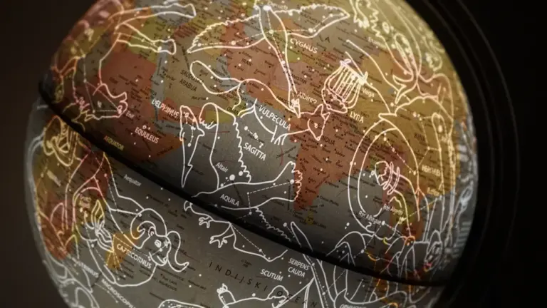 Ein beleuchteter Globus mit Sternbildern in einer dunklen, mystischen Atmosphäre.