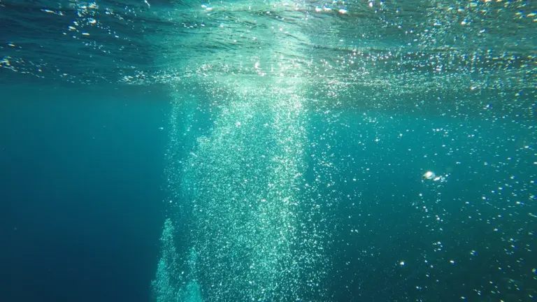 Nahaufnahme von Luftblasen unter Wasser, die wie aufsteigende Gedanken wirken.